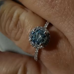 Art deco style aquamarine CZ engagement ring set in a 925 halo setting.